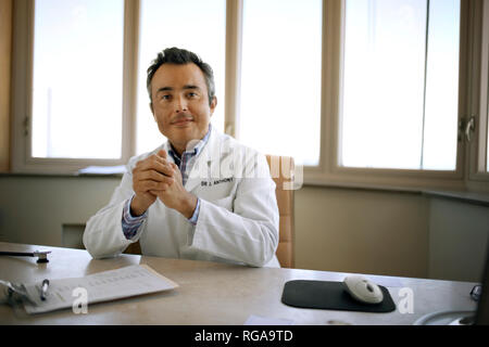 Portrait d'un médecin d'âge mûr assis à son bureau. Banque D'Images