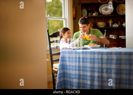 Père et fille manger ensemble lors d'une table à manger. Banque D'Images