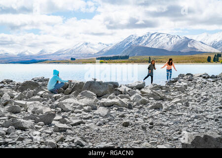 LAKE TEKAPO NOUVELLE-ZÉLANDE - Le 14 octobre 2018, trois jeunes touristes profiter de l'expérience de l'estran rocheux de faible niveau d'eau au bord du lac Banque D'Images