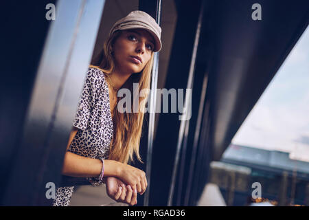 Attractive young woman in leopard print dress looking away Banque D'Images