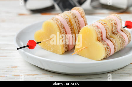 Mini sandwiches pain jambon fromage parmesan en brochettes sous la forme de cœurs. Le jour de la Saint-Valentin. Le petit-déjeuner pour les proches. Focus sélectif et copy space Banque D'Images