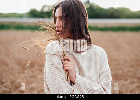 Portrait de jeune femme avec col roulé pull surdimensionné portant des oreilles Banque D'Images