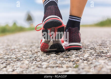 Pieds de femme sportive sur chemin de campagne en été Banque D'Images