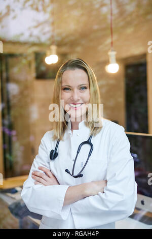 Portrait of smiling female doctor with stethoscope derrière la vitre Banque D'Images