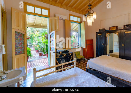 Chambre coloniale avec deux lits anciens et de grandes portes coloniale et d'une fenêtre Banque D'Images