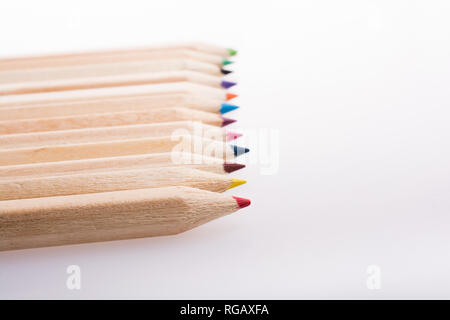 Crayons de couleur dans une rangée sur un fond blanc Banque D'Images