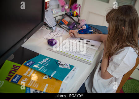 Jeune fille faire ses maths homeowrk à son bureau Banque D'Images