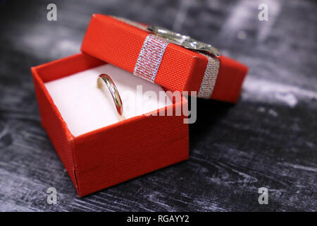 Boîte-cadeau avec anneau d'or sur la table en bois vintage. Concept de proposition de mariage, bijoux, cadeaux Saint Valentin, romantique présent Banque D'Images