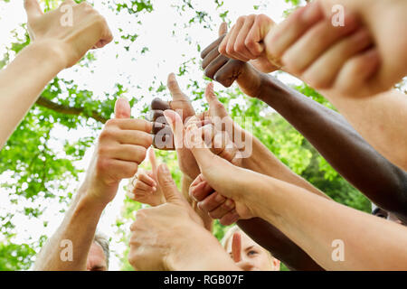 Les jeunes en équipe avec Thumbs up comme un signe de succès et l'approbation Banque D'Images