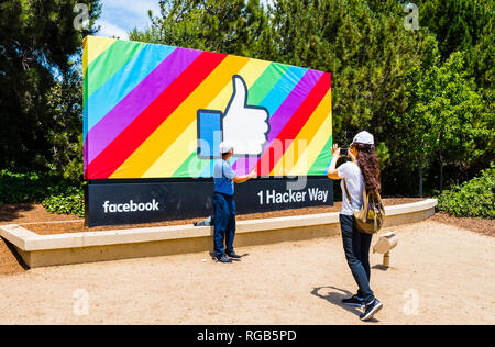 18 juin 2018 Menlo Park / CA / USA - Visiteurs posant devant le Facebook Like Button ; fond drapeau arc-en-ciel, la célébration de la fierté LGBT mois ; en Banque D'Images