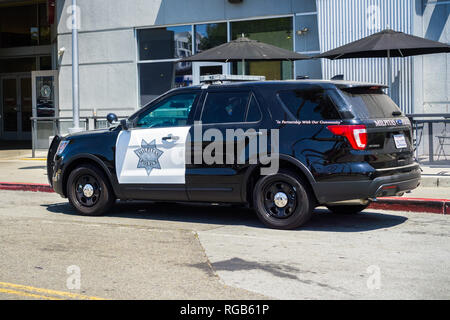 1 août, 2018 Milpitas / CA / USA - voiture de police s'est arrêté sur le bord de la route en face d'un restaurant ; Great Mall, South San Francisco bay area Banque D'Images