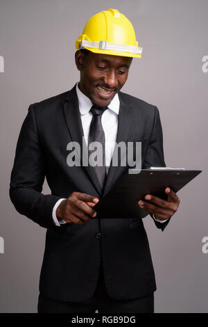 Beau jeune homme d'Afrique avec un casque de protection contre le bac gris Banque D'Images