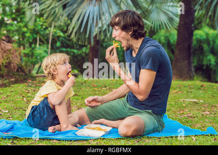 Cute kid garçon d'âge préscolaire en bonne santé mange des pommes de terre frites avec du ketchup avec son père. l'enfant de manger des aliments malsains. Banque D'Images