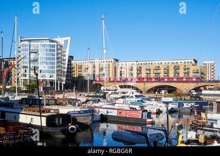 Limehouse Basin dans l'East End londonien, avec des bateaux, de nouveaux appartements et le Docklands Light Railway en arrière-plan Banque D'Images