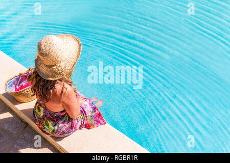 Espagne, Andalousie, Malaga, Mondrón, femme assise à côté de la piscine, Banque D'Images