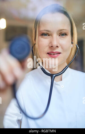 Portrait of female doctor holding stethoscope Banque D'Images