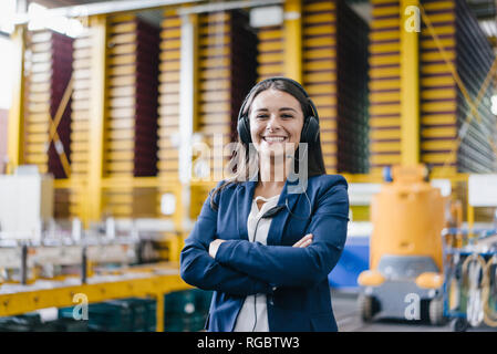 Woman standing in logistics centre, with arms crossed Banque D'Images