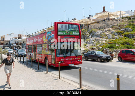 RETHYMNO, Crète - AOÛT 2018 : Red bus de tourisme est conduite le long de la rue. Banque D'Images