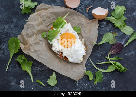 Œuf frit sur tranche de pain gris recouvert de crème au paprika Banque D'Images