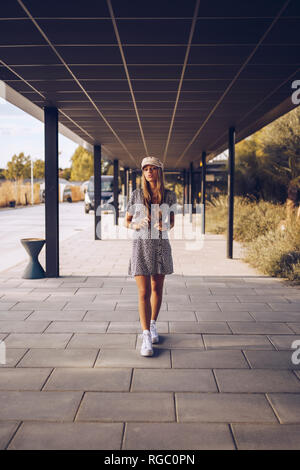 Attractive young woman walking in arcade Banque D'Images