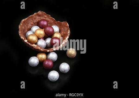 Sophistocated moderne d'or, d'argent au chocolat & broze oeufs de pâques, sur un fond noir. Banque D'Images