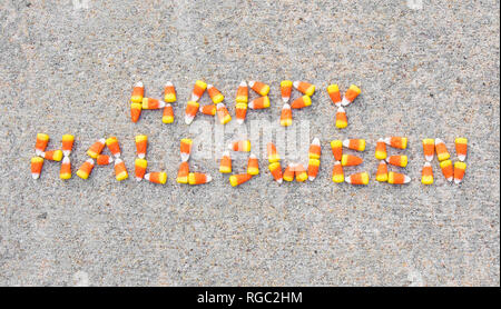 L'expression Happy Halloween énoncées avec candy corn sur un trottoir. L'expression est Centerd sur la photo. Banque D'Images