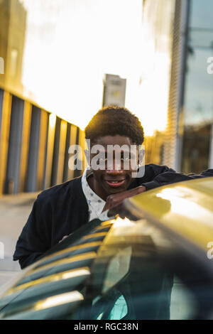 Portrait d'un jeune homme noir, debout près d'une voiture Banque D'Images