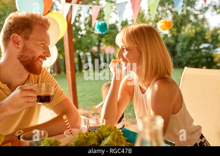 Couple heureux en face de l'autre on a garden party Banque D'Images