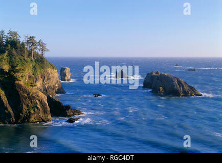 USA (Oregon), Samuel Boardman State Park, soir vue sud de Arch Rock Vue mer vers les cheminées et pointe boisée. Banque D'Images