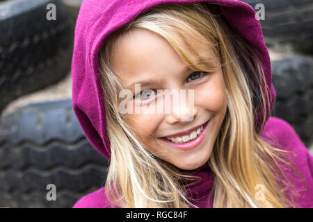 Portrait of smiling blonde girl wearing Hooded Jacket rose Banque D'Images