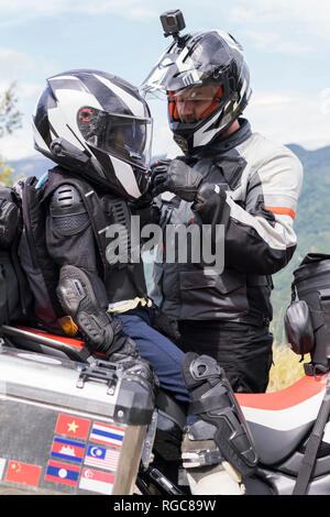 Le père et le fils ayant une pause au cours d'un voyage en moto Banque D'Images