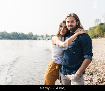 Happy young couple in love embrassant du riverside Banque D'Images