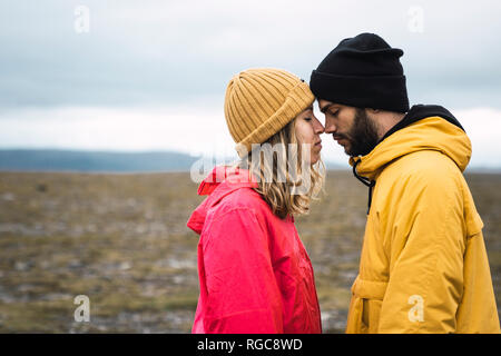 Jeune couple se frottant le nez affectueusement, Laponie, Norvège Banque D'Images