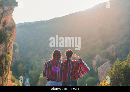 L'Espagne, Alquezar, vue arrière de deux jeunes femmes en randonnée partager une couverture Banque D'Images