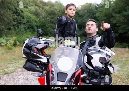 Le père et le fils ayant une pause au cours d'un voyage en moto Banque D'Images