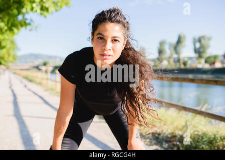 Portrait de jeune femme sportive ayant une pause au Riverside Banque D'Images