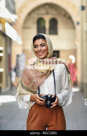 L'Espagne, Grenade, les jeunes touristes Arabes femme portant le hijab, à l'aide d'appareil photo pendant la visite de la ville Banque D'Images