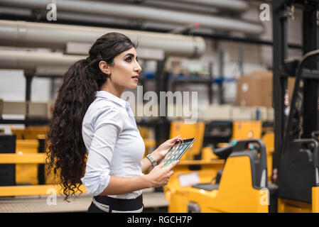 Woman holding tablet en magasin d'usine marbre Banque D'Images