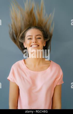 Portrait of smiling young woman tossing ses cheveux Banque D'Images
