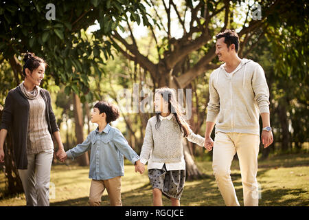 Famille avec deux enfants asiatiques dans la marche heureux et souriants. Banque D'Images