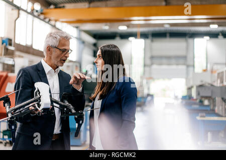 Une femme d'affaires dans l'entreprise de haute technologie, de discuter de la production de drones Banque D'Images