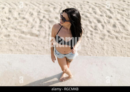 Jeune femme debout près de la plage, elevated view Banque D'Images