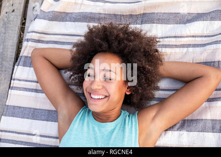 Portrait of happy woman lying on a blanket outdoors Banque D'Images