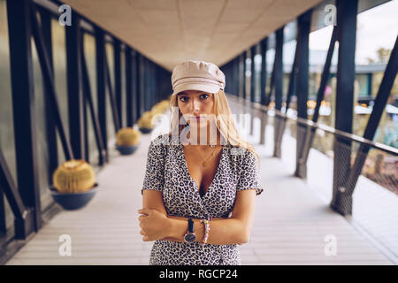 Portrait of attractive young woman standing in arcade portant robe imprimé léopard Banque D'Images