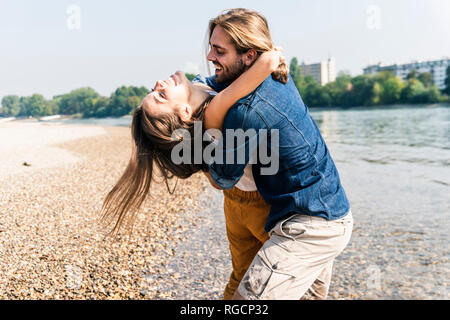 Happy young couple in love embrassant du riverside Banque D'Images