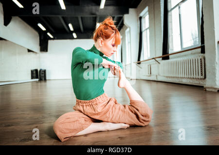 Rousse jeune professeur de yoga avec cheveux bun à cause Banque D'Images