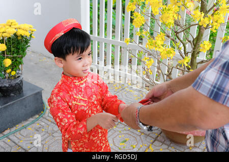 Grand-père en petit-fils l'argent de la chance de donner le premier jour de la nouvelle année lunaire vietnamienne Tet Banque D'Images