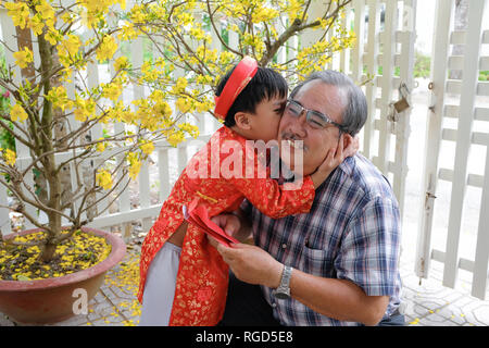 Grand-père en petit-fils l'argent de la chance de donner le premier jour de la nouvelle année lunaire vietnamienne Tet Banque D'Images