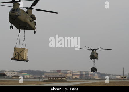 CH-47 Chinook décoller après que des soldats de la 123e Bataillon de soutien de la Brigade, 3e Brigade Combat Team, 1re Division blindée, fixer l'équipement avec succès au cours de la charge sous élingue operations training 7 janvier au Camp Humphreys, République de Corée. Les opérations de charge capacité des soldats d'essai à déplacer de l'équipement d'un endroit à l'autre. (U.S. Photo de l'armée par la FPC. Edwin Petzke, 20e Détachement des affaires publiques) Banque D'Images