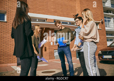 Groupe d'étudiants heureux avec des documents à l'extérieur permanent Banque D'Images